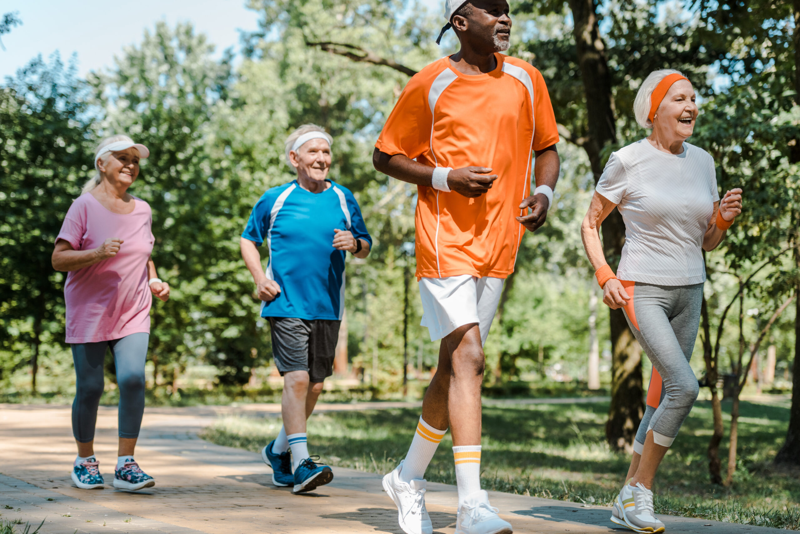 sportive multicultural and retired men and women running in park