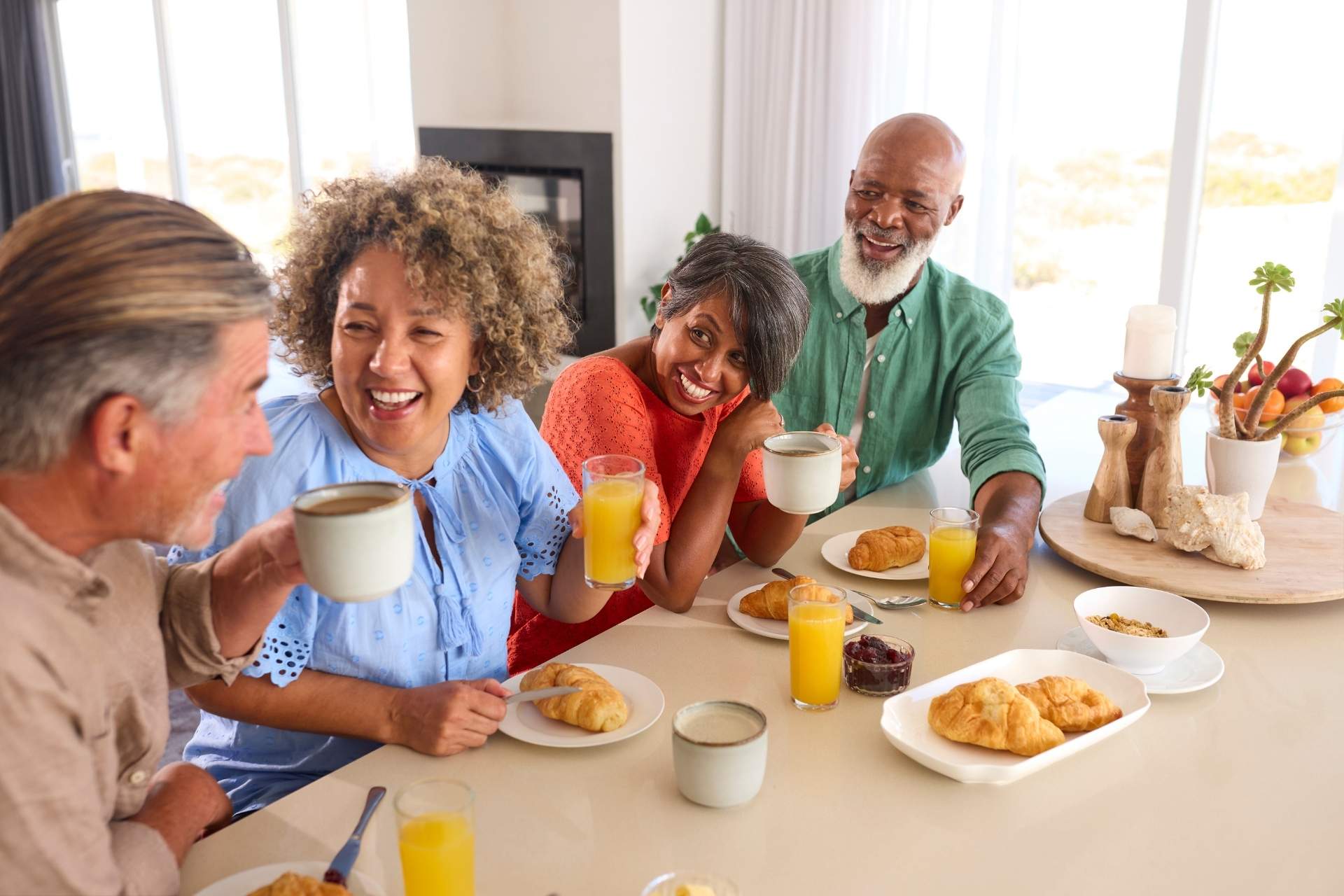 A group of seniors laughing and enjoying breakfast together.